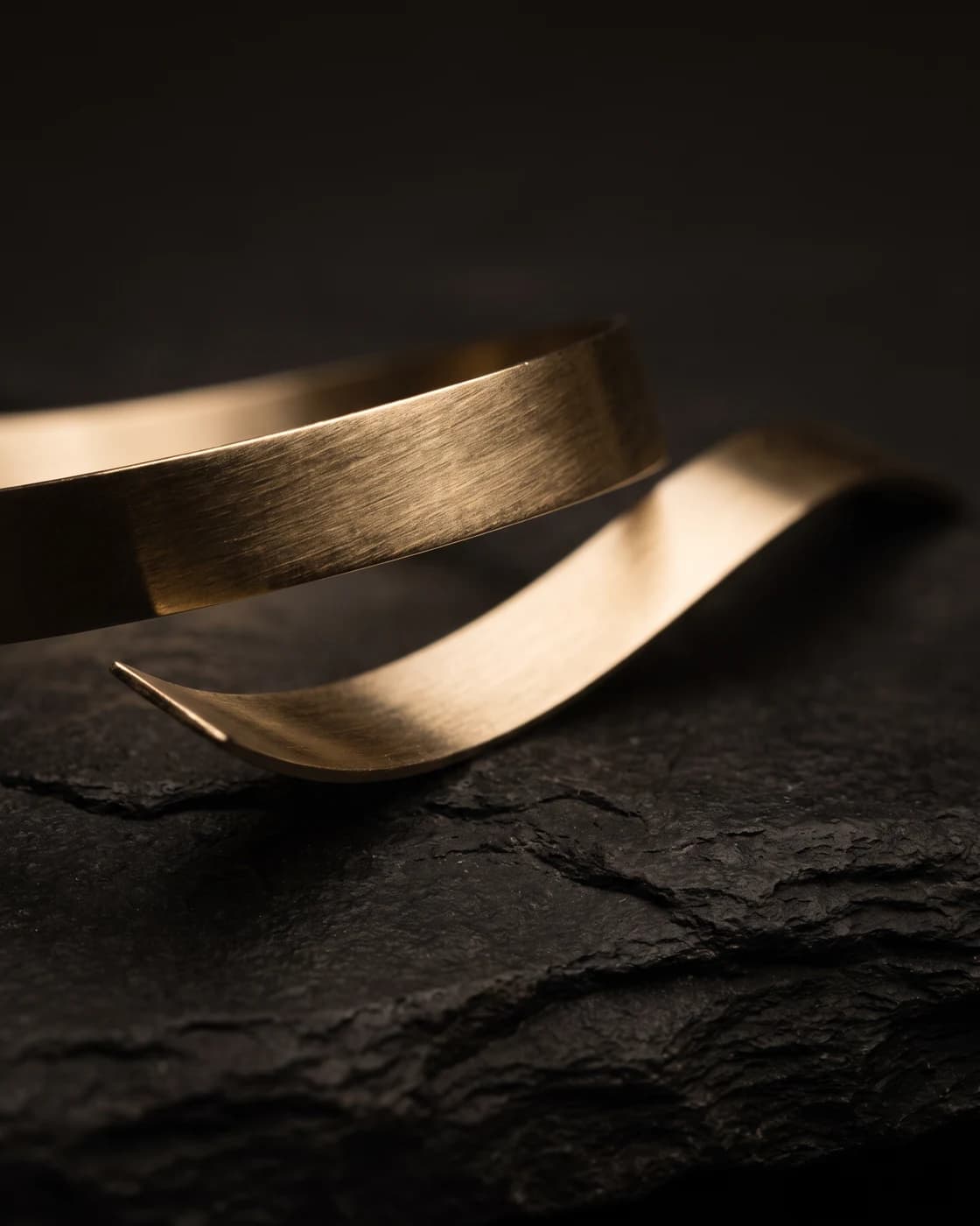 Gebürstetes Gold auf dunklem Stein – künstlerische Materialstudie